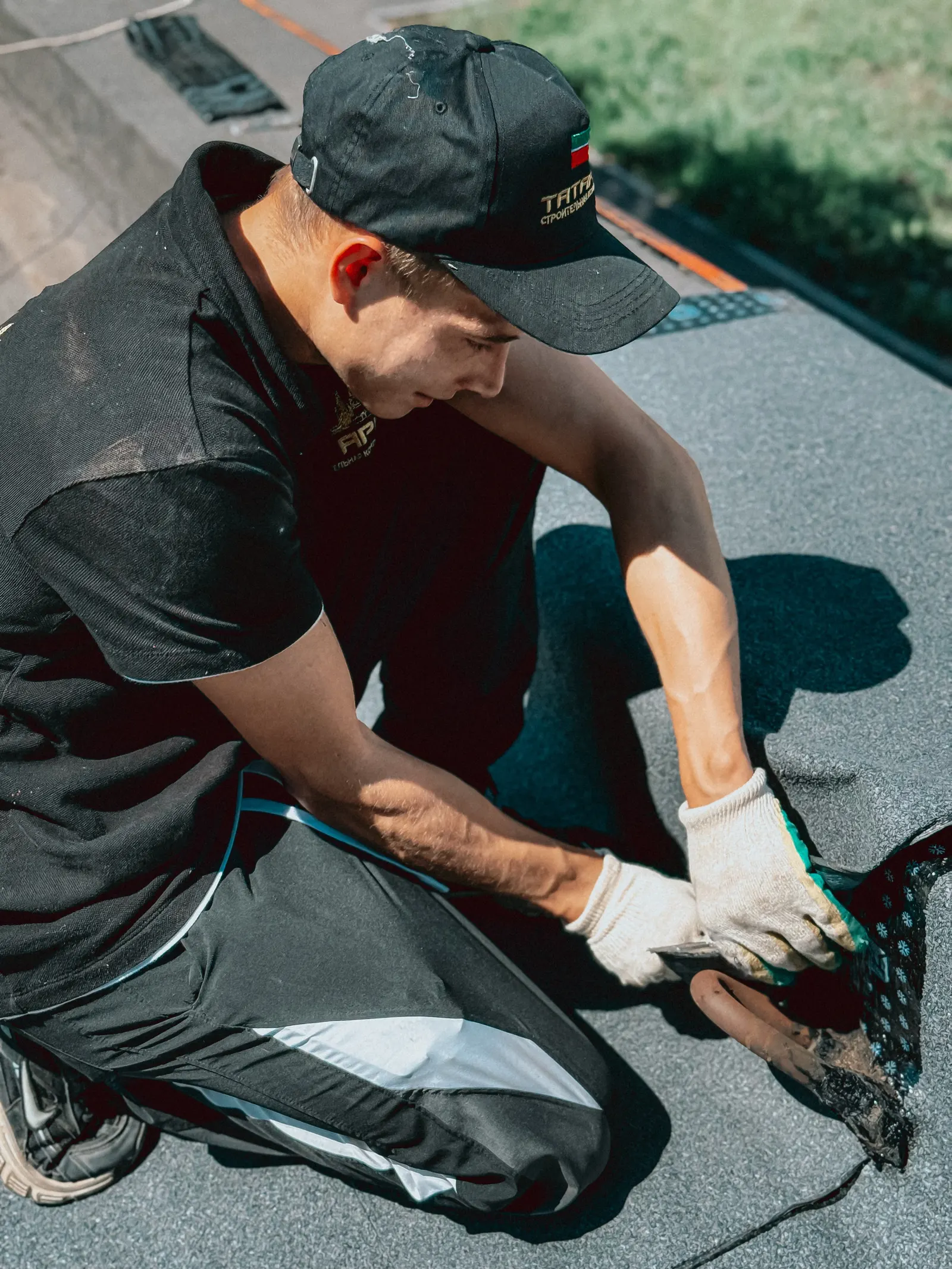 Roofer applying waterproof membrane on a flat commercial roof