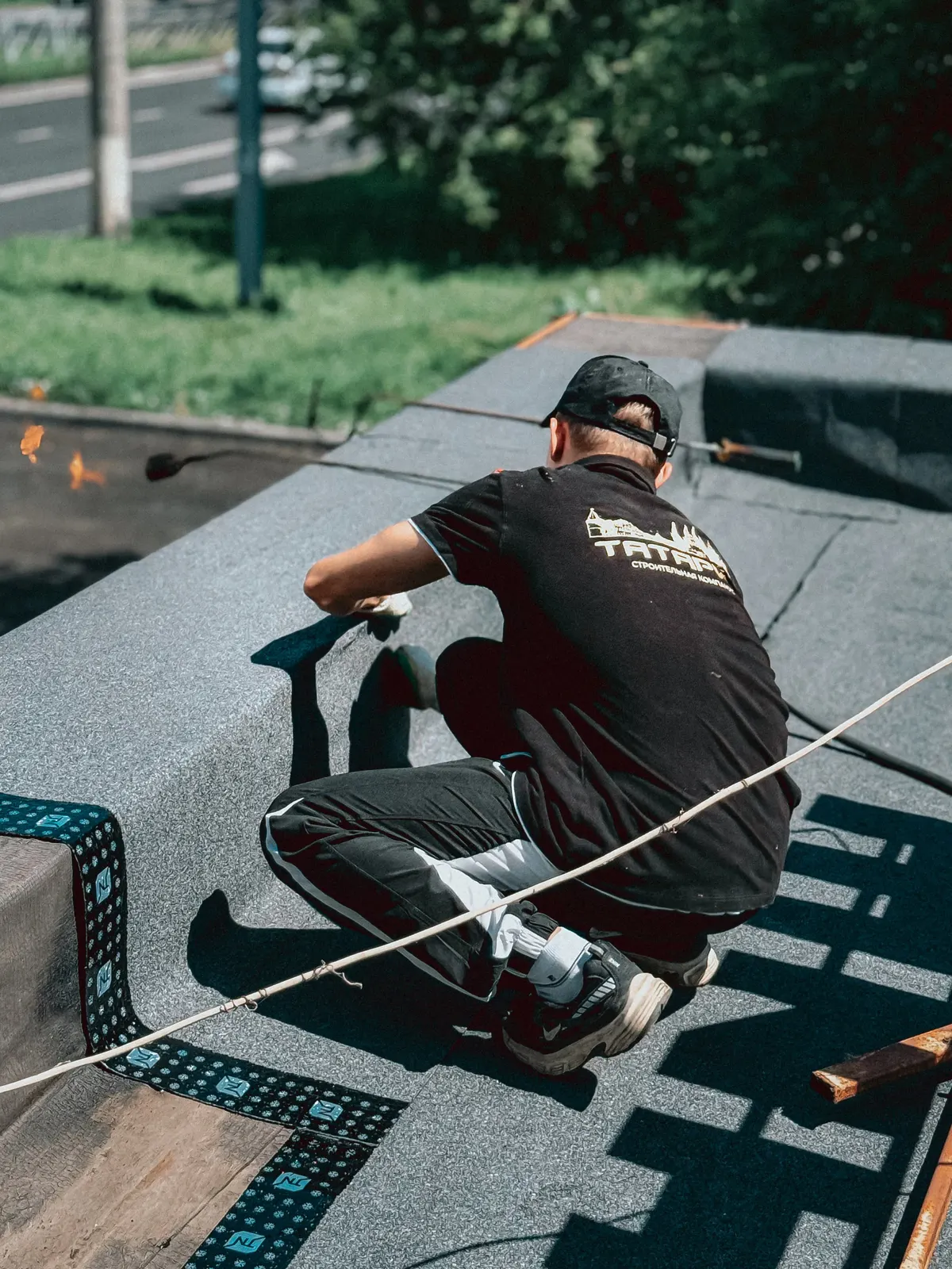 Roofer installing membrane roofing material on a commercial flat roof