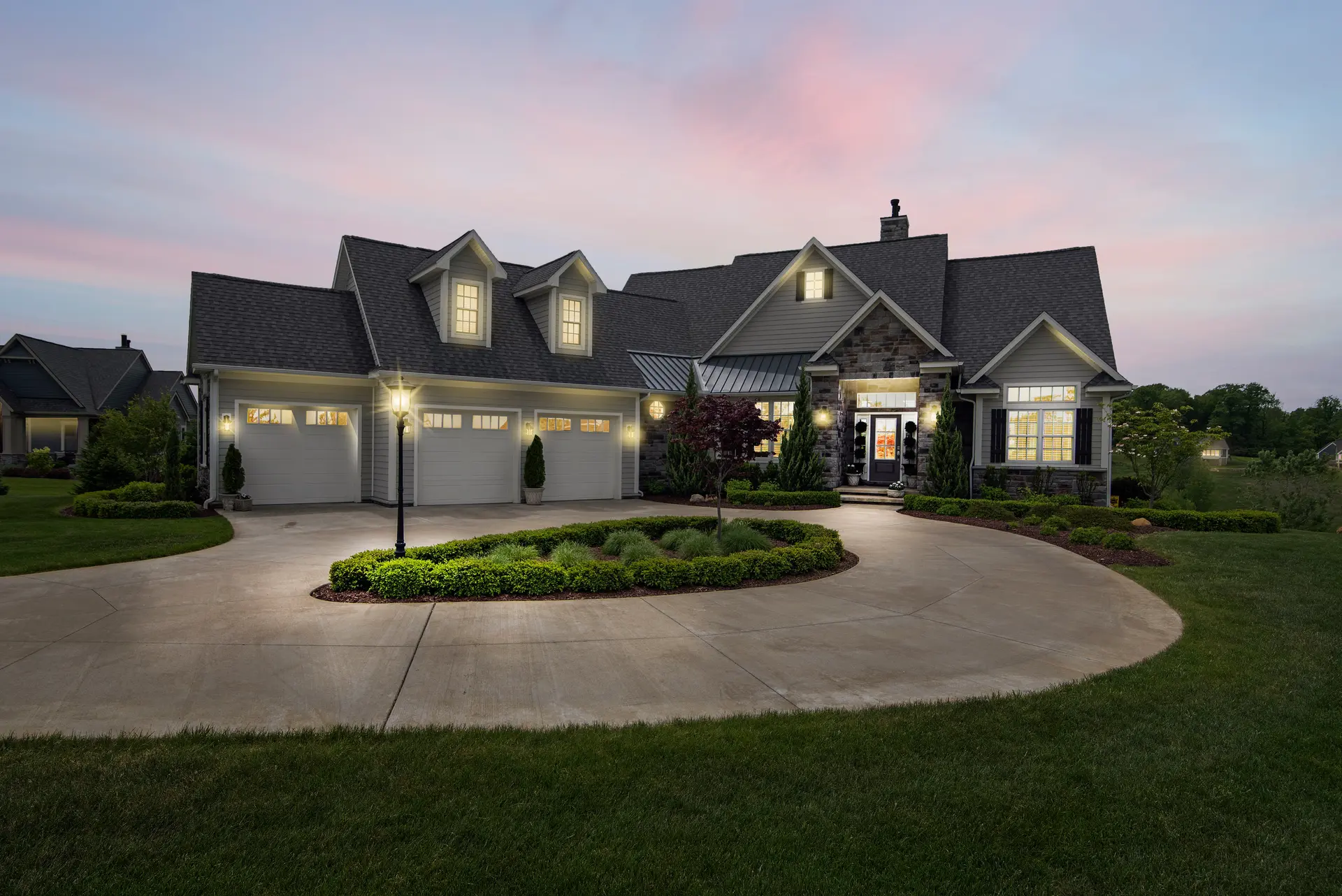 An upscale home at dusk with a freshly installed architectural shingle roof